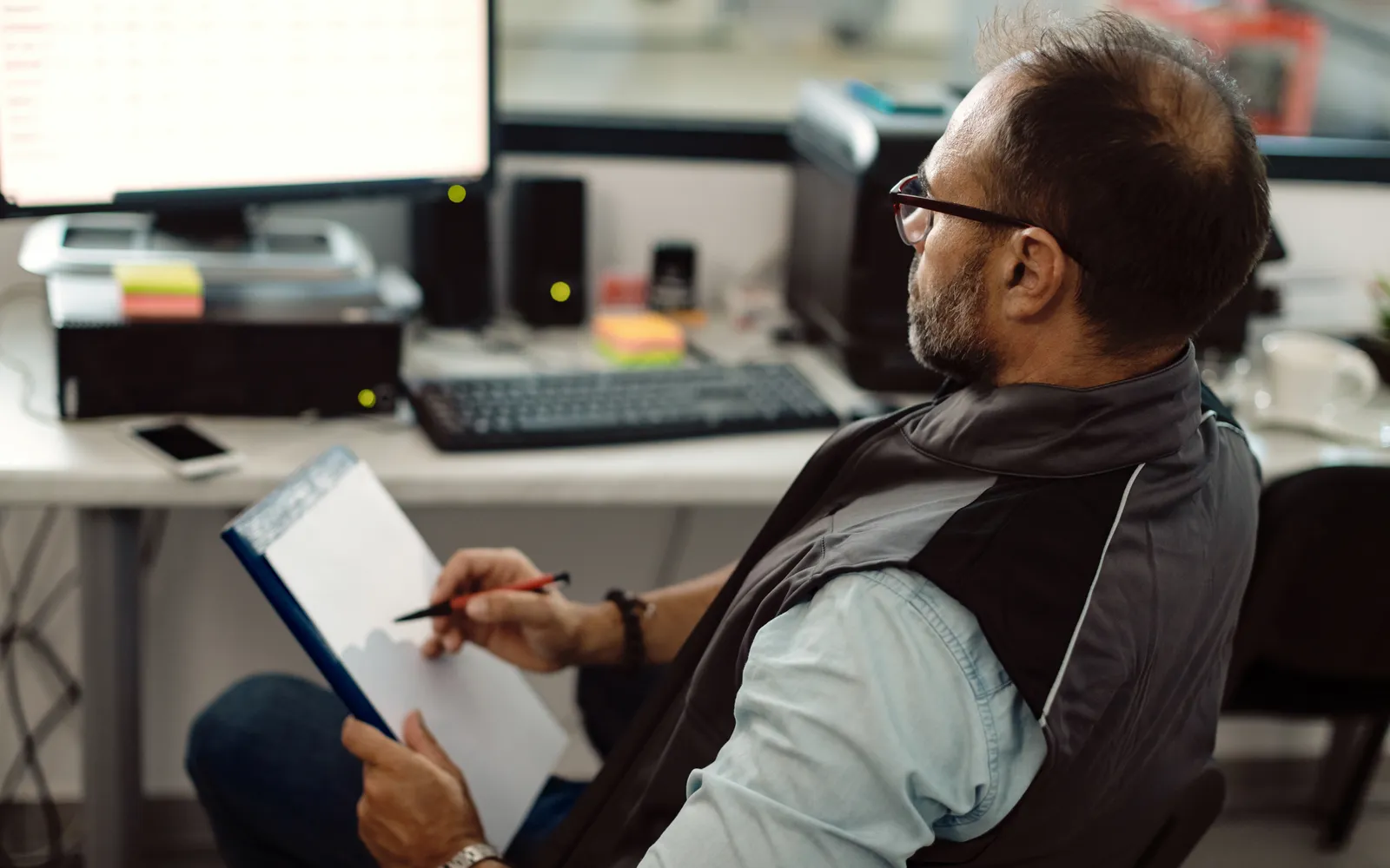 A garage owner working through paperwork at his desk